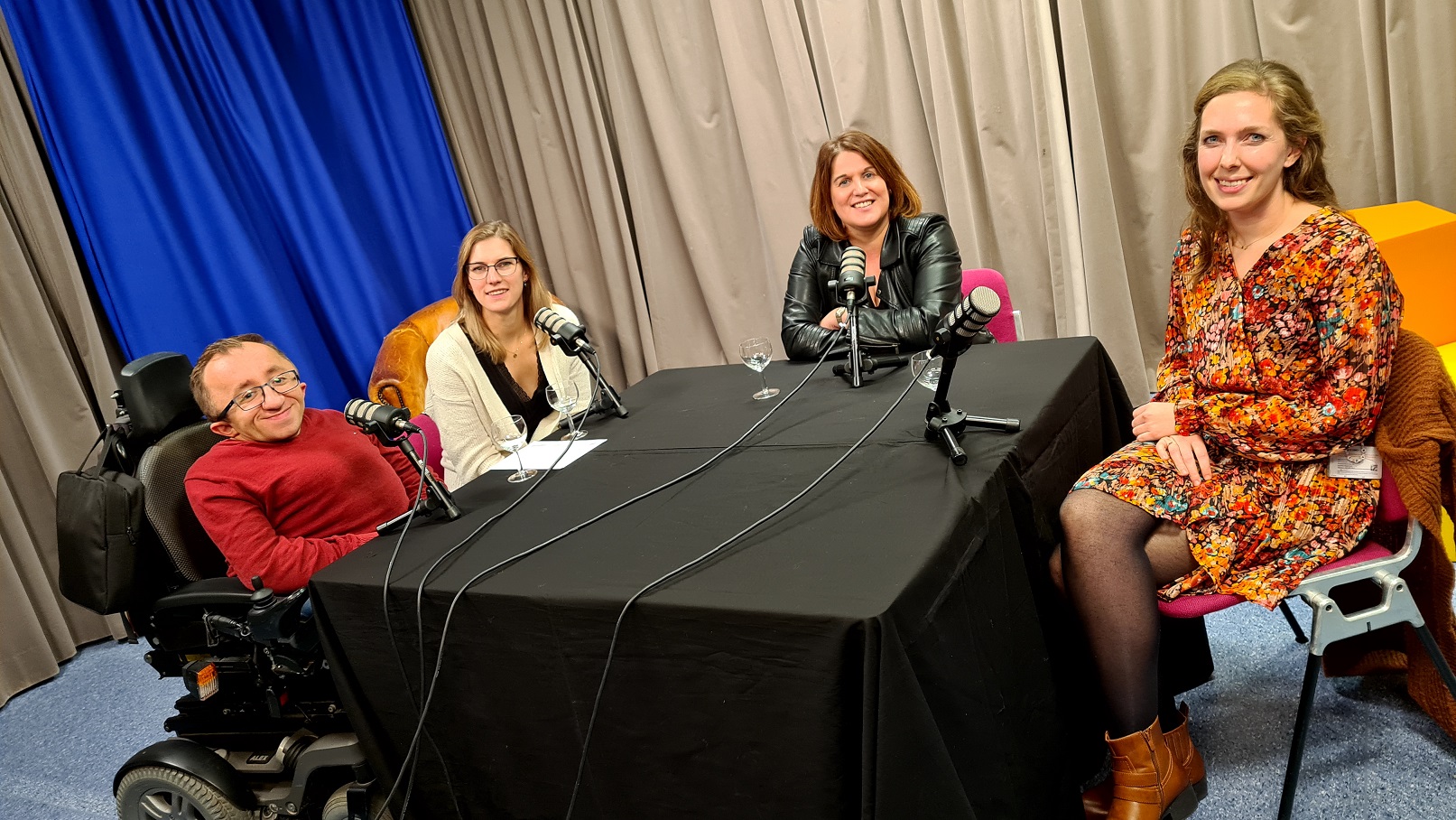 Gasten en presentatrice in de studio tijdens de opname van de podcast
