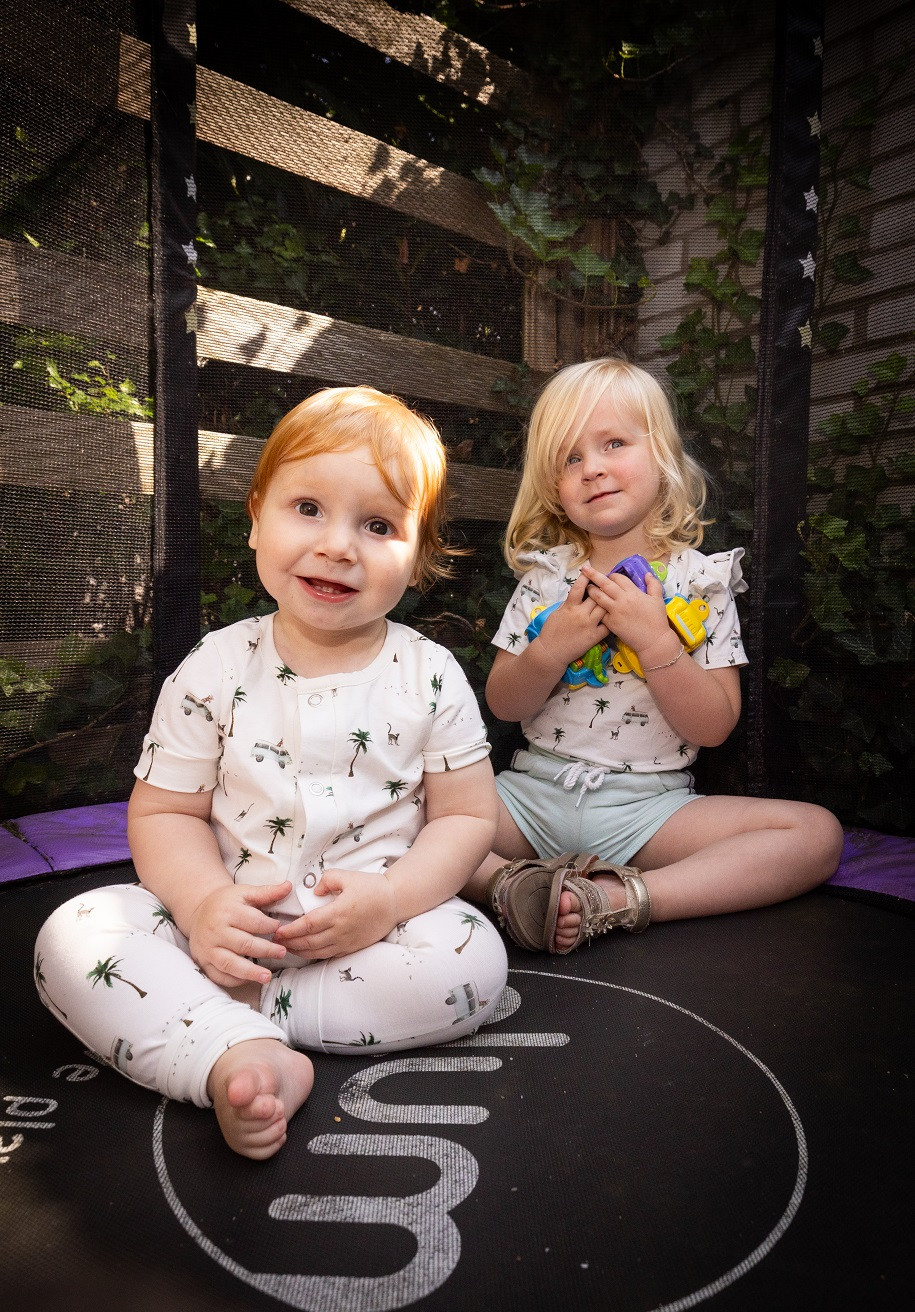 2 kinderen zittend op een trampoline