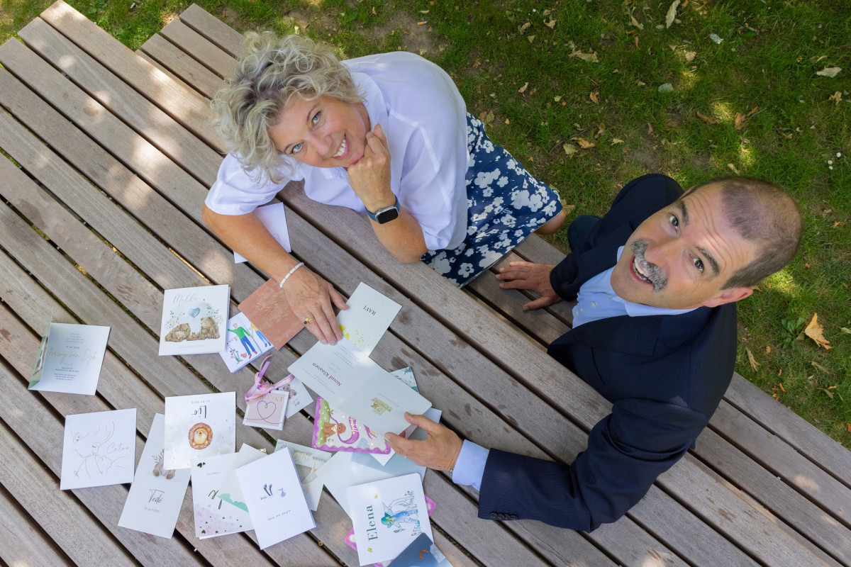 Edith Coonen en Jos Dreesen met geboortekaartjes op tafel 